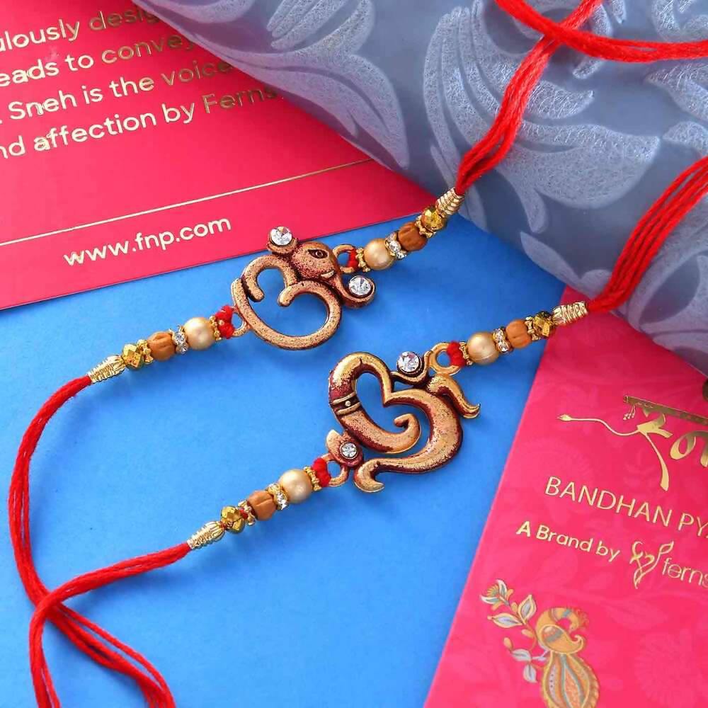 2 Divine Om Rakhis & Pista Kaju Roll Box Hamper Combo